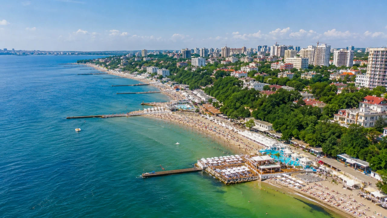 Вид згори на берегову лінію з пляжами, хвилерізами та міськими будівлями